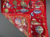an image of a red scarf with a picture of hot air balloons on it