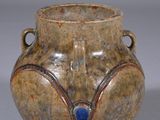 a brown vase with a blue decoration on it
