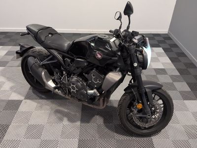 une moto noire garée sur un sol à damier