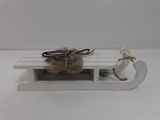 wooden sled with a fur ball on top of it on a white surface