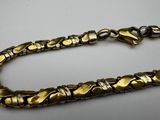 a close up of a gold bracelet on a white surface