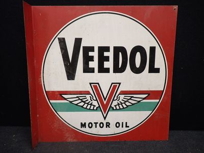 une vieille affiche publicitaire pour l'huile moteur Veedol sur fond noir