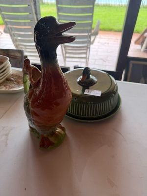 une figurine de canard posée sur une table, à côté d'une assiette de nourriture