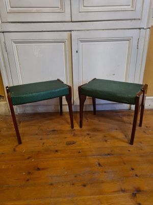 two stools sitting on the floor in front of a cabinet