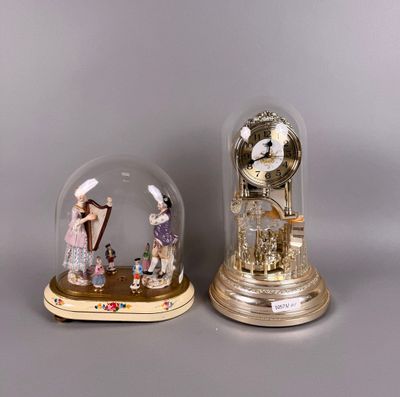 Pendule sous globe à manège animé en résine doré.