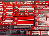 a lot of red and white train cars on a table