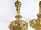 pair of antique brass candlesticks on a white background