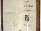 un livre ouvert posé sur une table, avec une bougie dessus