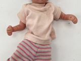 a baby doll that is laying down on a white surface