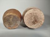 pair of old pottery vases sitting on a white surface