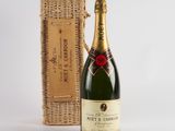 an image of a bottle of champagne next to a wicker basket