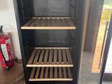 a wine cooler that is open on the floor