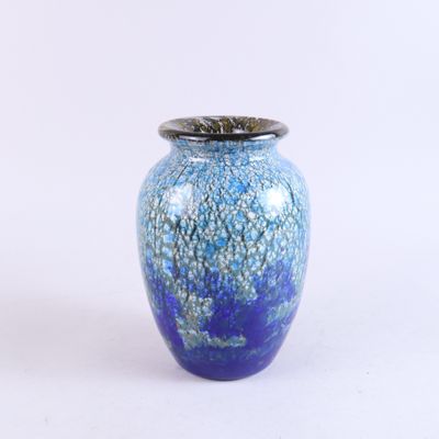 un vase bleu avec un couvercle argenté sur fond blanc