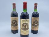 trois bouteilles de vin posées les unes à côté des autres sur une surface blanche