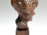 an image of a sculpture of a man ' s head on a wooden base