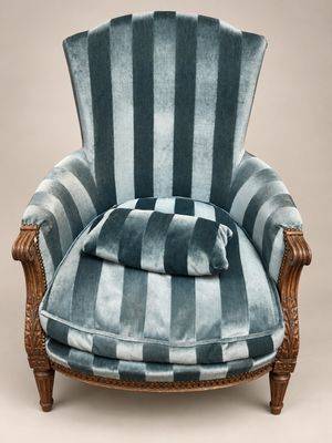 une photo d'une chaise à rayures bleues sur laquelle est posé un coussin