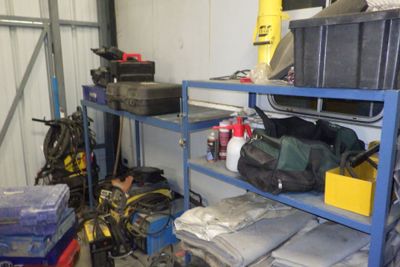 de nombreux sacs et autres objets sur les étagères du garage