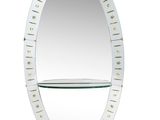 un miroir ovale muni d'une étagère et d'une autre étagère en dessous