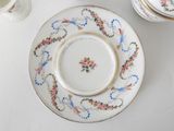 a plate with a floral design on it next to a cup and saucer