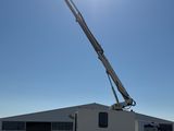 a white truck with a crane on it parked in a parking lot
