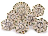 several plates with flowers are arranged on a white surface