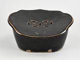 an image of a small black bowl with holes in it