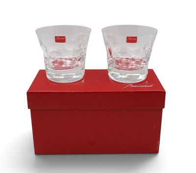 deux verres à shot posés sur une boîte rouge, elle-même posée sur une surface blanche