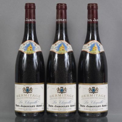 three bottles of wine are lined up on a table