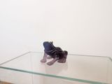 une petite figurine représentant un éléphant violet posée sur une table en verre