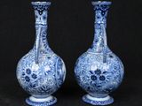 pair of blue and white vases sitting on a black surface