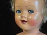 a close up of a doll with blue eyes on a black background