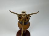 a small brass oil burner on a wooden stand