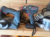 a cordless drill and a cordless hammer on a wooden shelf