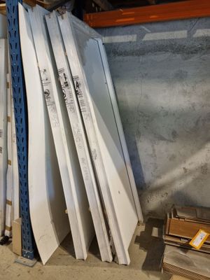 une pile de panneaux blancs empilés les uns sur les autres dans un entrepôt