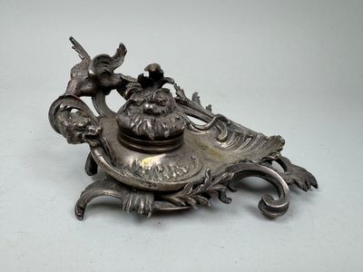 a silver plate with a bird on top of it