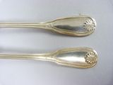 two spoons that are sitting on a white table