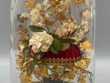 a glass dome with flowers inside of it on a table