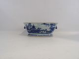 a small blue and white bowl with a landscape on it