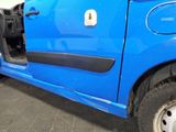 a small blue car with its door open in a garage
