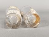 two empty glass bottles sitting on a white surface
