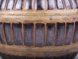 a close up of a vase on a white surface