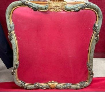 une photo d'une chaise rouge sur laquelle repose un cadre doré