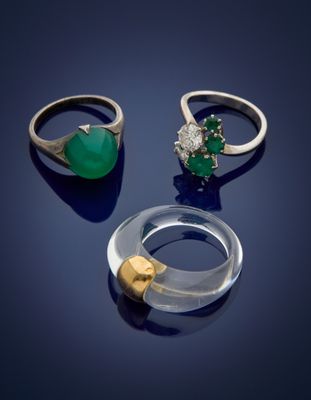 trois bagues et une bague ornée d'une pierre verte sur un fond bleu