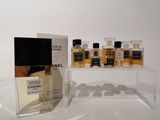 trois flacons de parfum Chanel posés sur une table à côté d'une boîte de parfums