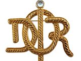 un gros plan d'une broche en or sertie d'un diamant