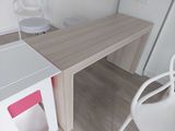 une chaise blanche et un bureau dans une petite pièce