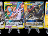 Quatre cartes Pokémon sont alignées les unes à côté des autres sur un fond noir.