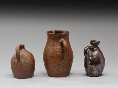 trois vases marron posés les uns à côté des autres sur une surface blanche