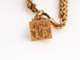 a gold necklace with a picture of a bird on it