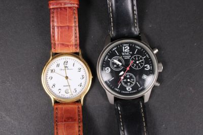 two watches sitting next to each other on a black surface